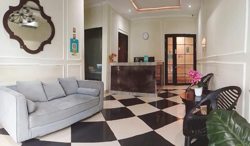 a living room with a couch and a checkered floor at Flamboyan Residence Cipete in Jakarta