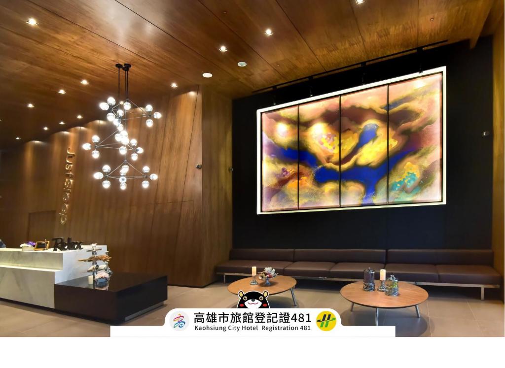 a lobby with two tables and a large painting on the wall at Just Sleep Kaohsiung Station in Kaohsiung