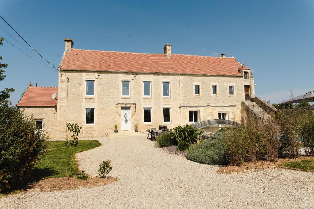 a large stone building with a red roof at L'écrin des quatre puits in Cesny-aux-Vignes