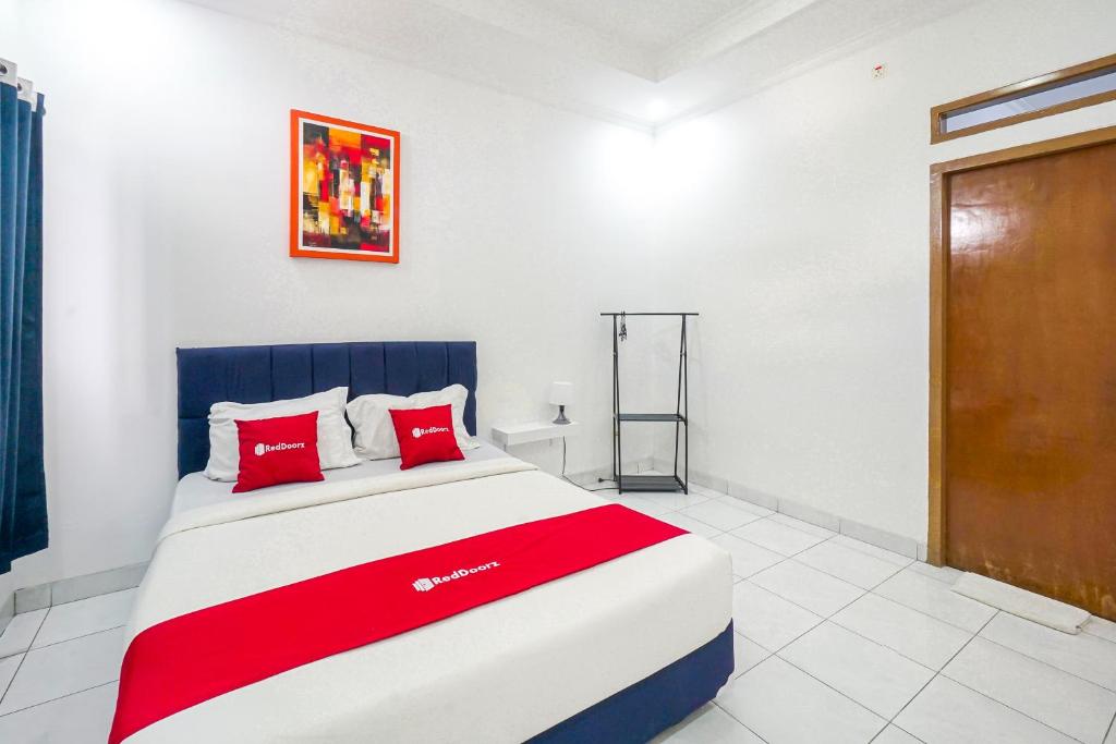 a bedroom with a large bed with red pillows at RedDoorz Plus near Universitas Maranatha Bandung 2 in Bandung