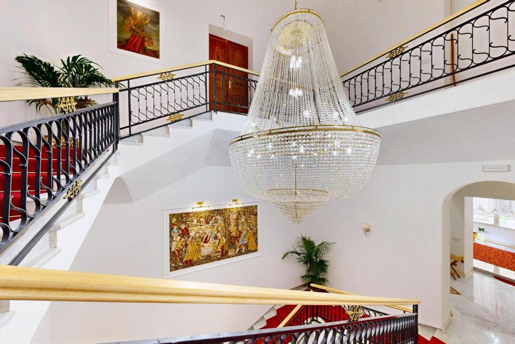 a large chandelier hangs from the staircase of a house at B&B Palazzo del Teatro in Agrigento
