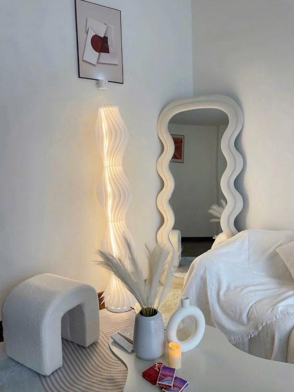 a bedroom with a white bed and a mirror at Bảo Châm Homestay in Gia Lâm Pho