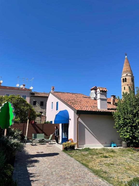 a white building with a clock tower in the background at Casa Ficcanaso in Caorle