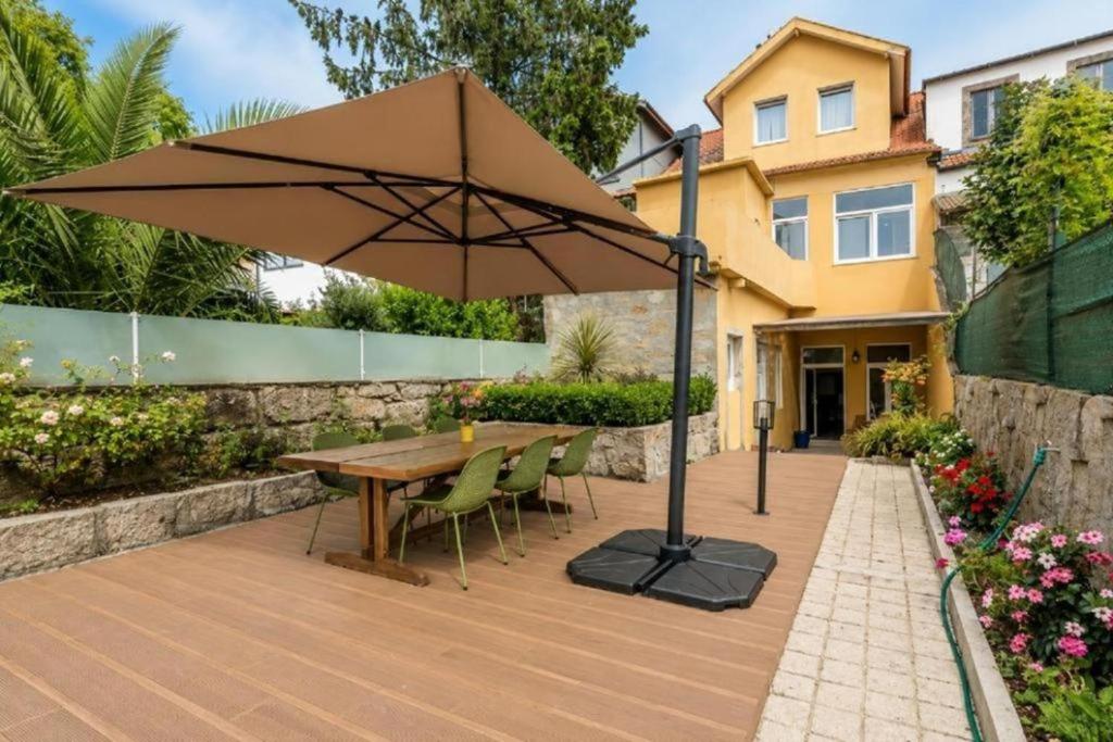 a wooden deck with a table and an umbrella at GuestReady - Vanzeleres Collection in Porto