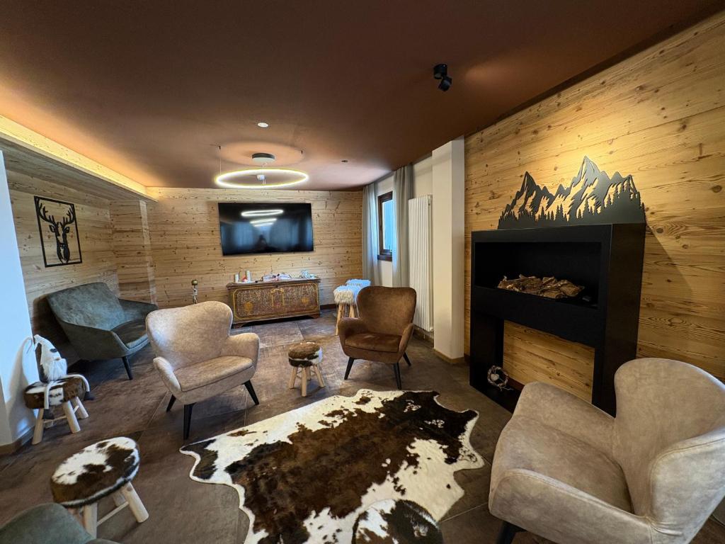 a living room with chairs and a fireplace at Hotel Kapriol in Folgarida