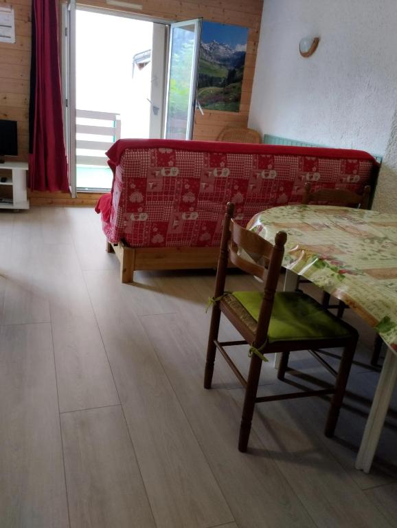 a living room with a couch and a table and a chair at Studio confortable à Cauterets - 40 m² - Vue sur la montagne in Cauterets