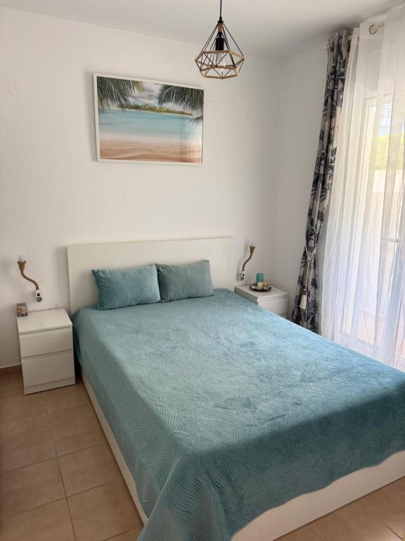 a bedroom with a bed with a blue comforter at Siviri Holiday Home in Siviri