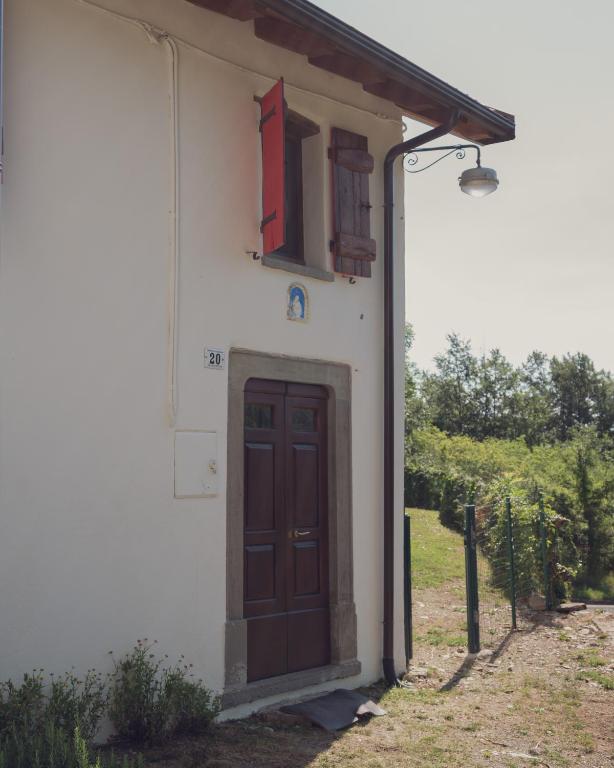 a white building with a brown door and a window at Casetta dalle finestre rosse in Bedonia