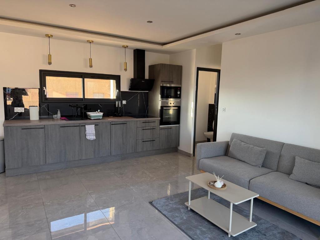 a living room with a couch and a kitchen at appartement Sorgues in Sorgues