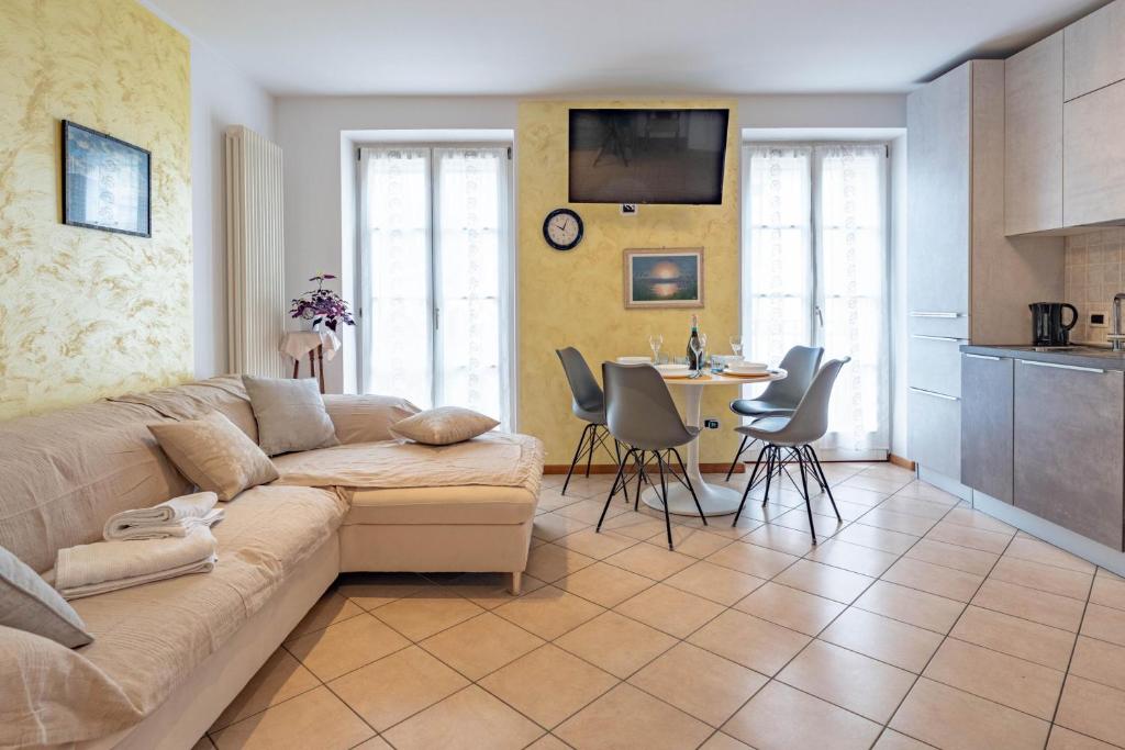 a living room with a couch and a table with chairs at Casa Cataleya, Tuenno Ospitar in Tuenno