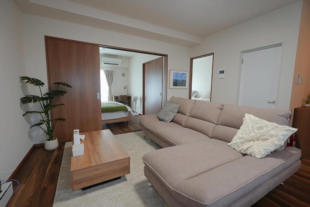 a living room with a couch and a table at INA HOUSE Miyakojima 302 in Miyakojima