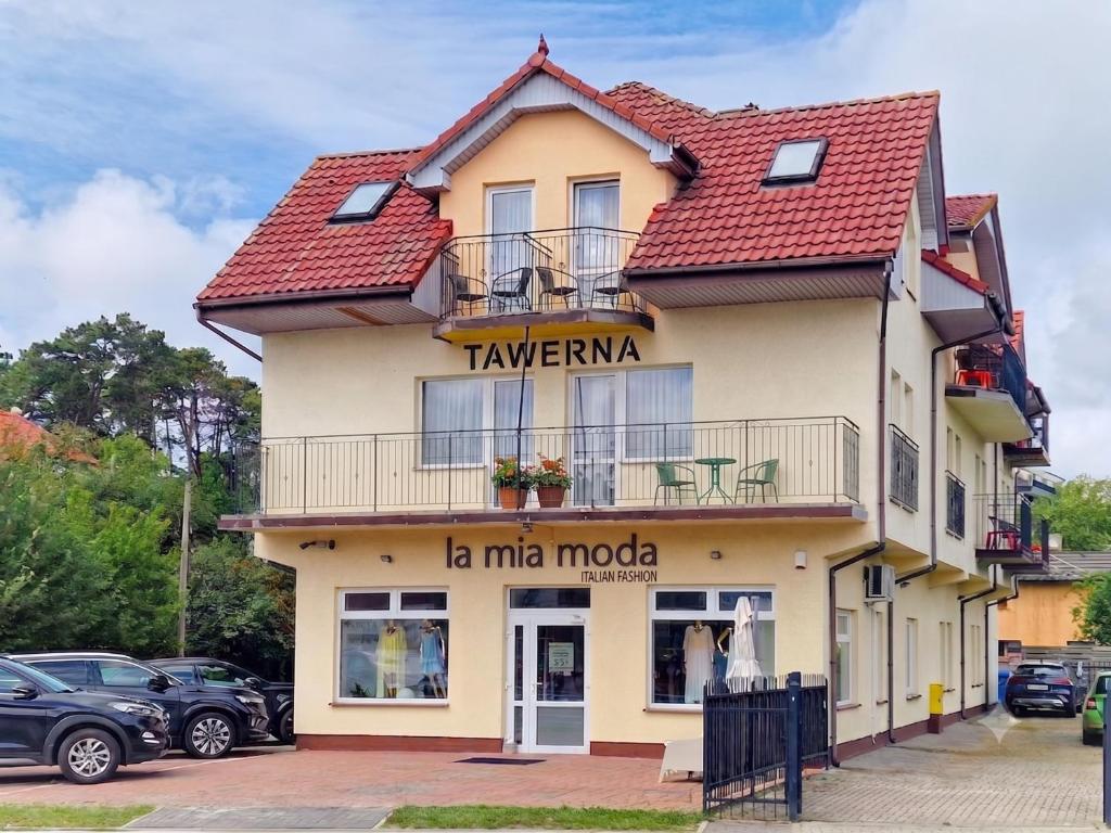 a building with a sign that reads taverna la mica at Tawerna Michałowscy in Mielno