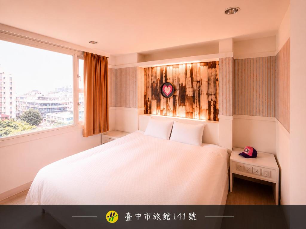 a bedroom with a white bed and a window at Kiwi Express Hotel - Zhong Zheng Branch in Taichung