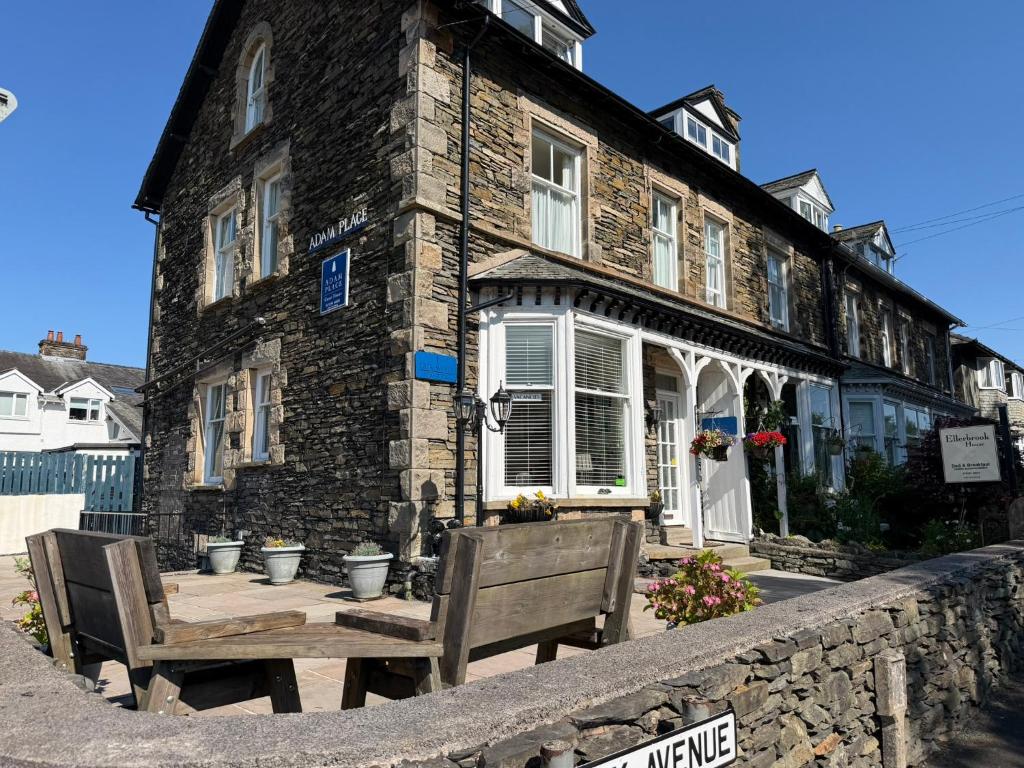 a stone building with two benches in front of it at Adam Place Guest House in Windermere