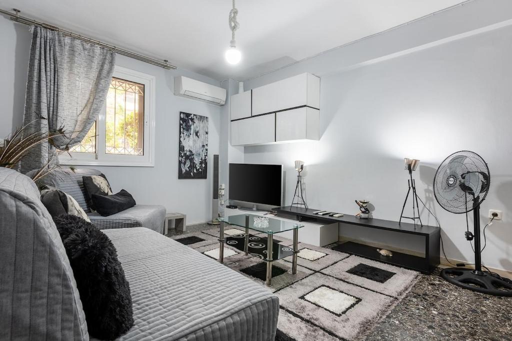 a white living room with a couch and a table at Amarysia Residence in Athens