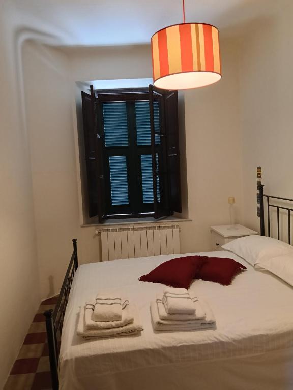 a bedroom with a bed with towels and a window at Casa Il Borgo in Tavernelle