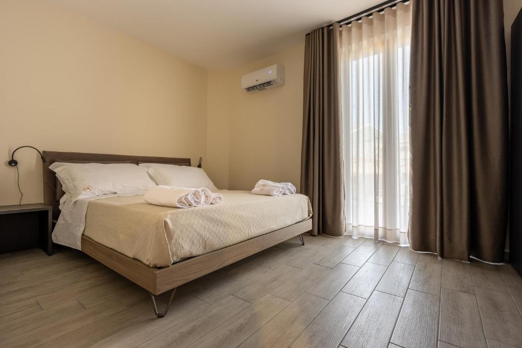 a bedroom with a bed and a large window at La Dimora Aragonese in Randazzo