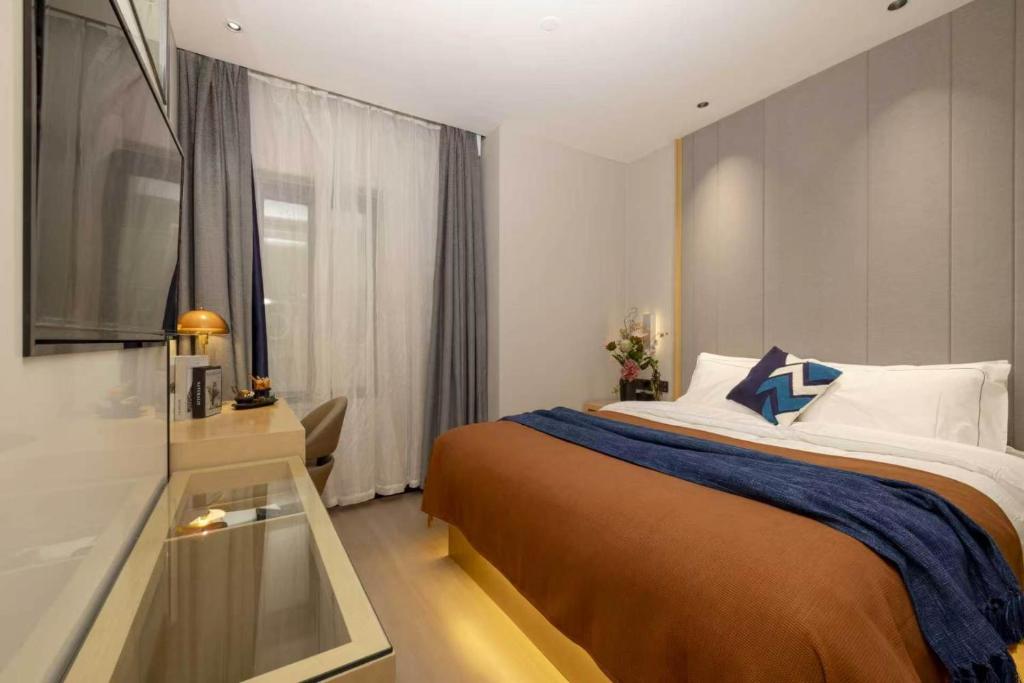 a bedroom with a large bed and a window at 啡诺艺术美居 in Guangzhou
