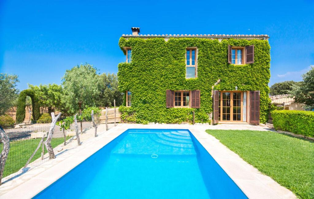 a villa with a swimming pool in front of a house at Sa Sort Llarga in Moscari
