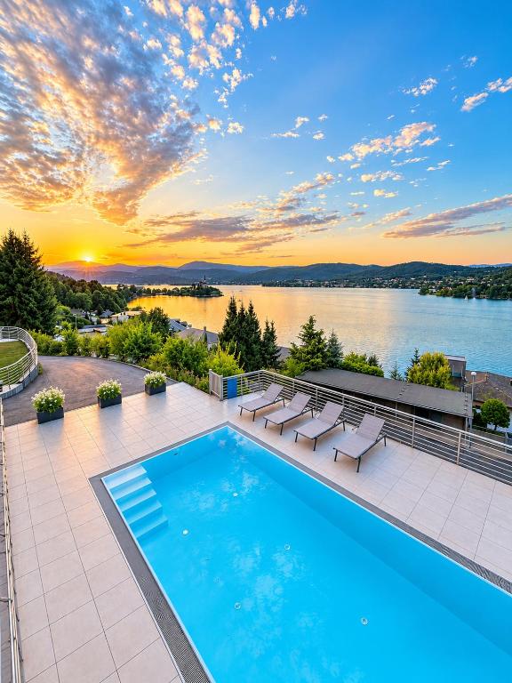 a swimming pool on the roof of a house with a sunset at Maria Blick in Maria Wörth