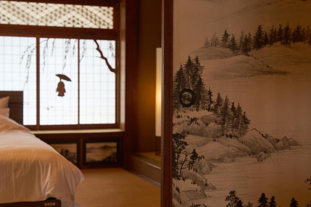 a painting on the wall of a bedroom at つむぎ in Shimoda