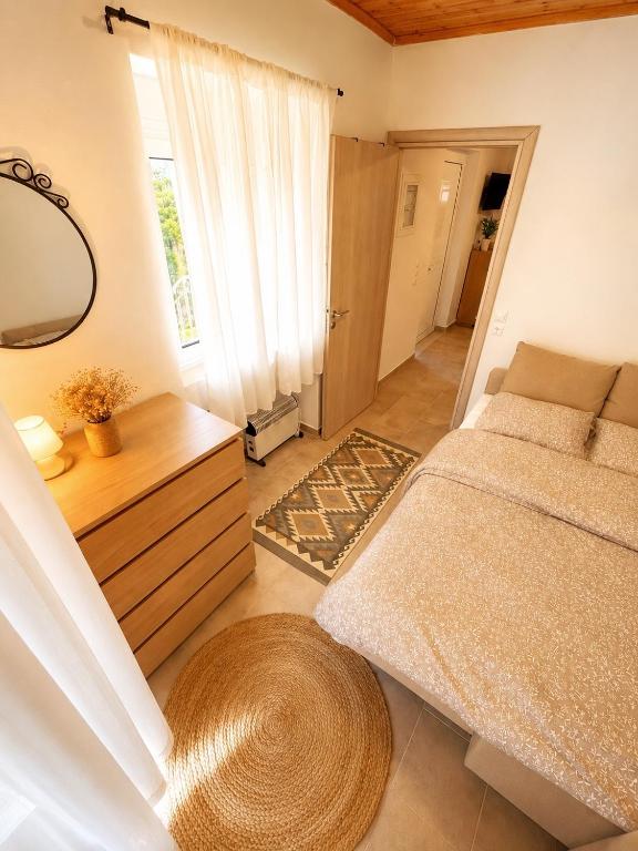 a small bedroom with a bed and a mirror at Taygetos hut in Dhirrákhion