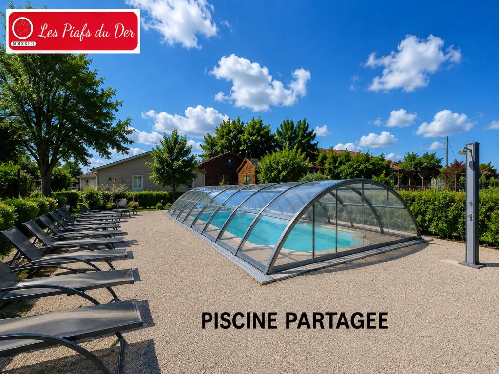 a glass pavilion with chairs and a swimming pool at les piafs du der 1 in Joncreuil