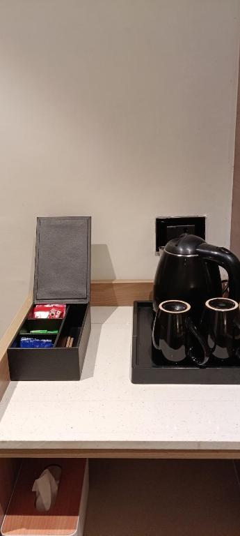 a stove with a tea pot and a box on a counter at MahantaINN in Faizābād