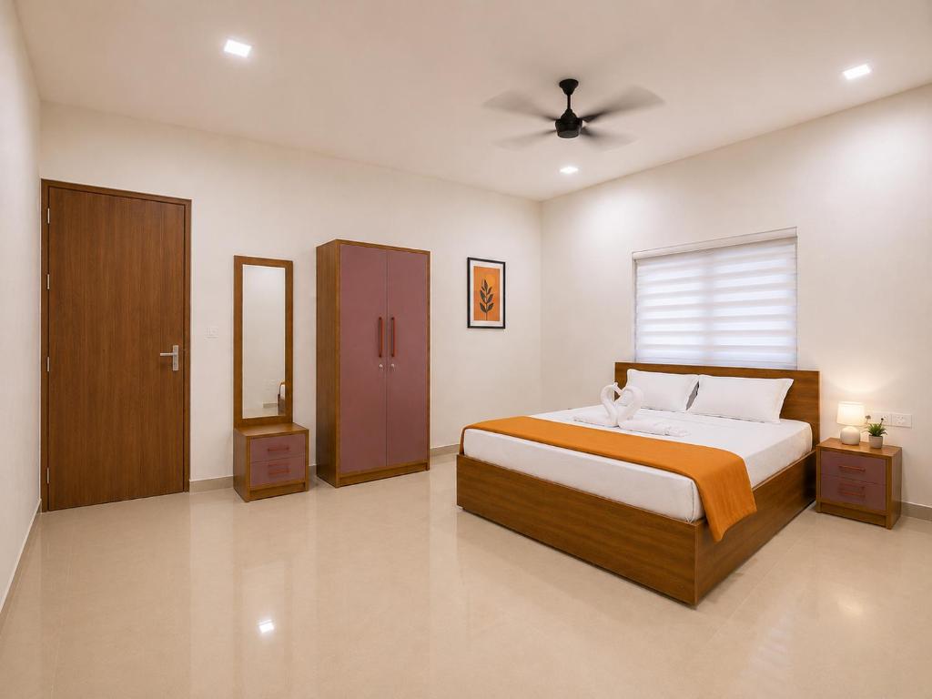 a bedroom with a bed and a ceiling fan at Kannur Easy Nest in Kannur