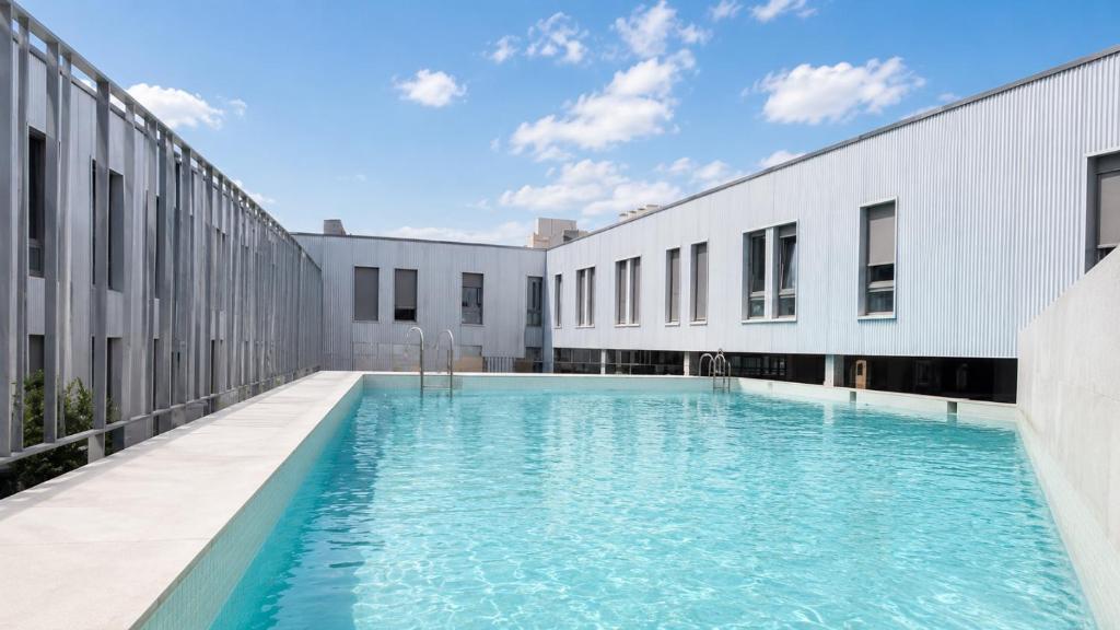 a swimming pool in the courtyard of a building at Canvas Valencia Burjassot in Burjassot