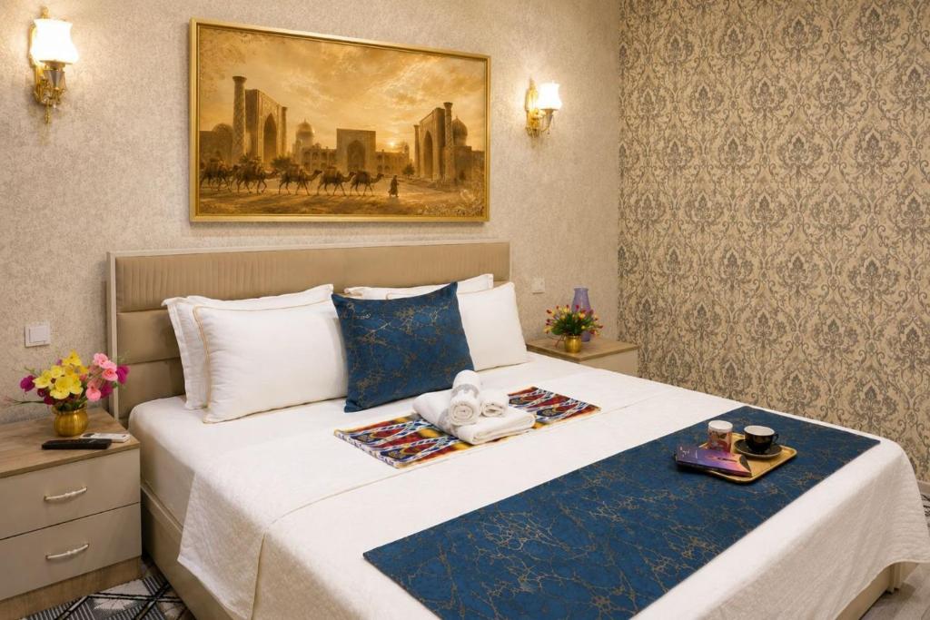 a hotel room with a bed with two towels on it at OSMAN villa in Samarkand