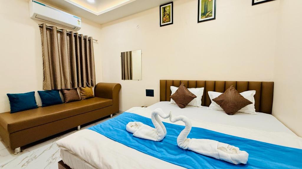 a bedroom with two swans towels on a bed at Hotel Gurukripa Palace in Maheshwar