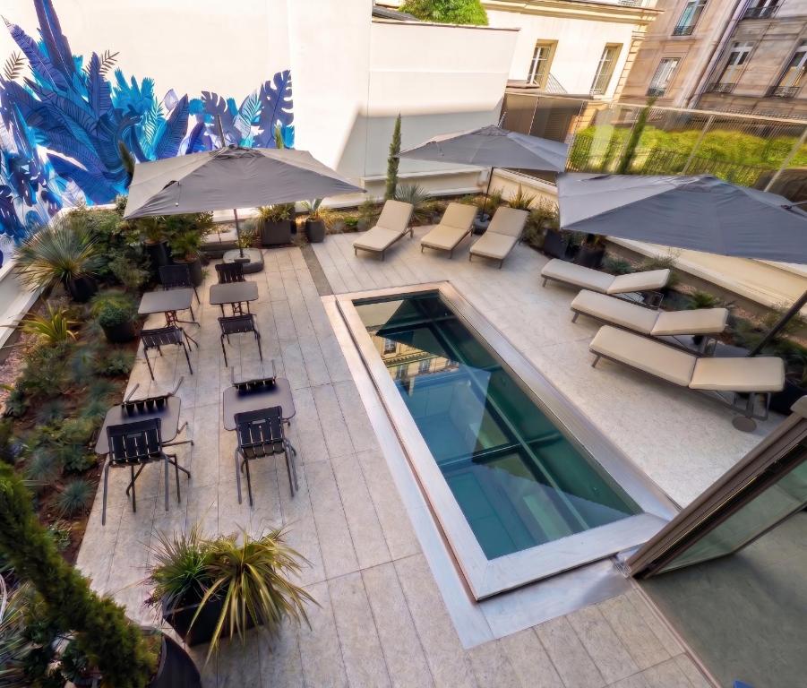 an overhead view of a patio with chairs and umbrellas at Hotel Leev Miromesnil & Spa in Paris