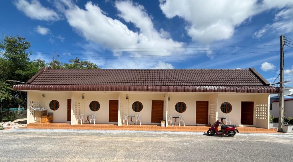 a house with a motorcycle parked in front of it at บ้านศรีสุธรรม3 Baansrisutham 3 in Don Sak