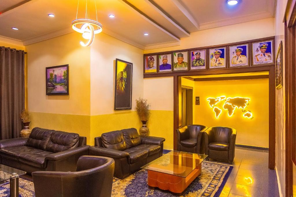 a living room with leather furniture and a yellow wall at Navy Guest House, Kaduna in Kaduna