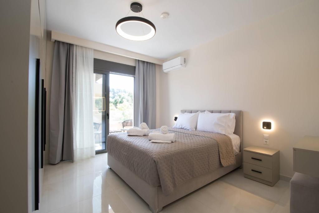 a bedroom with a bed and a large window at Glamour Residences 3-4 by CorfuEscapes in Análipsis