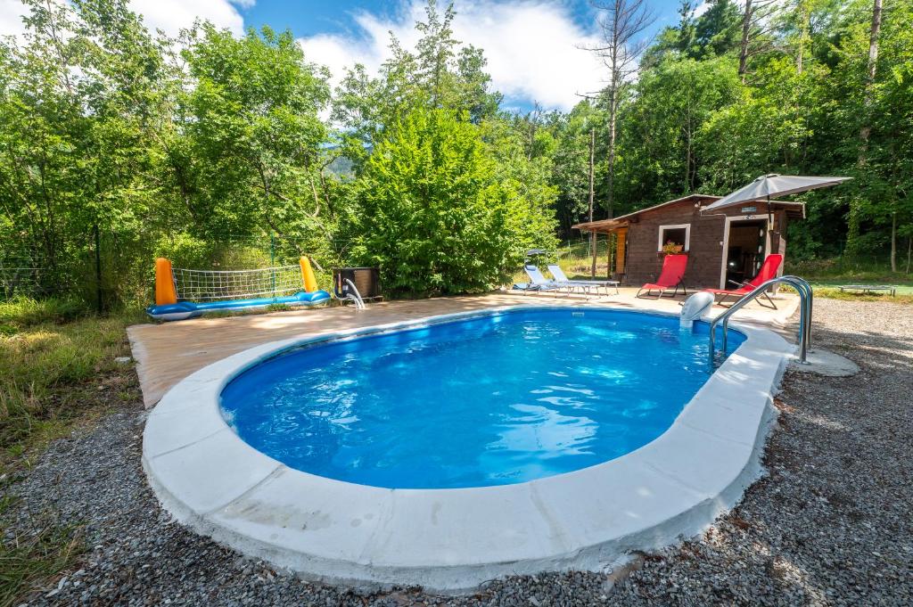 a pool with a wooden deck and a playground at 349 - Bosco Selvaggio con piscina, Palestra, Sport & Wellness - PARCHEGGIO GRATUITO INCLUSO in Reppia
