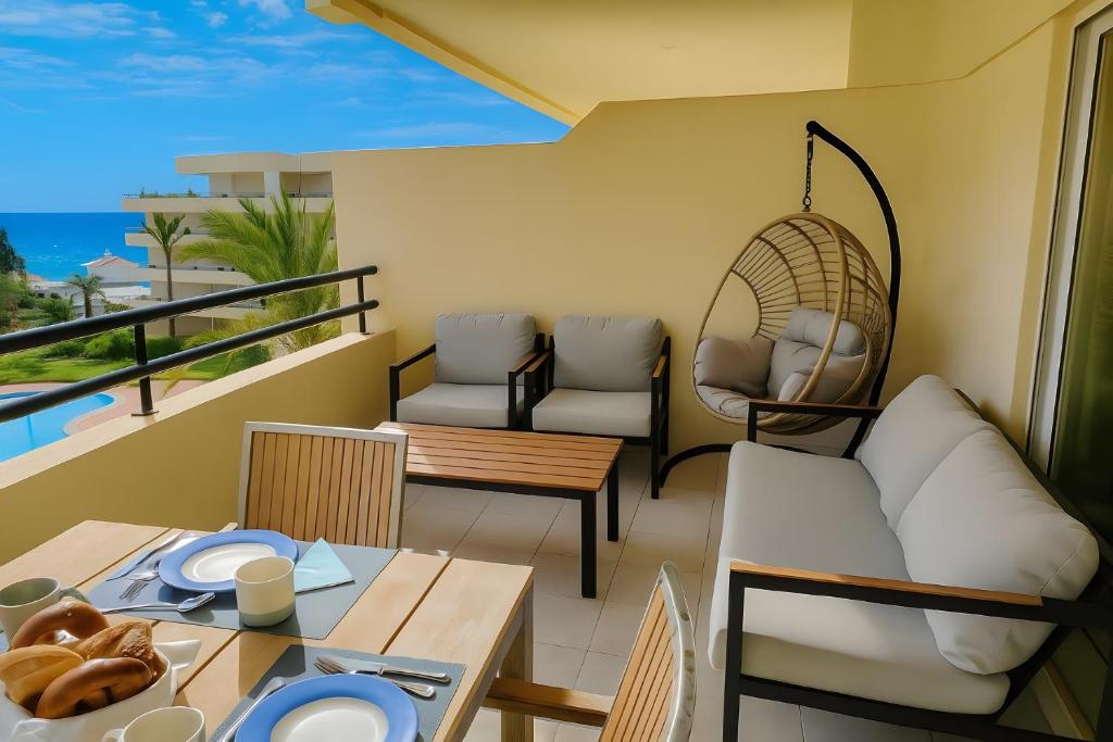 a room with a balcony with a table and chairs at T2 Galé Mar Retreat - Beach in Galé