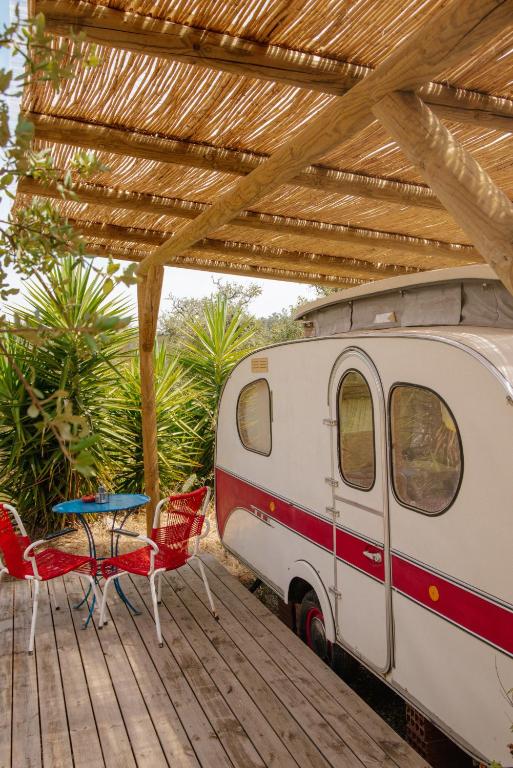 an rv sitting on a deck with a table and chairs at Três figos Caravan in São Luis