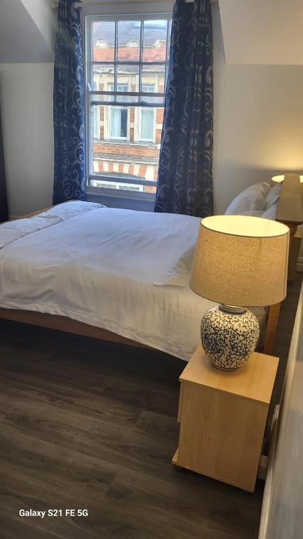 a bedroom with a bed and a table with a lamp at Montagu Street in Kettering