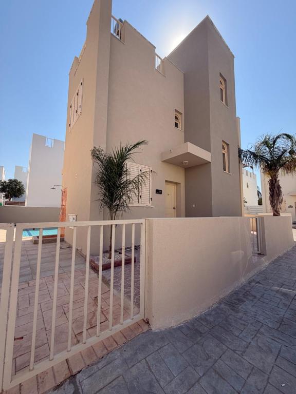 a house with a white fence in front of it at Pearl House in Paralimni