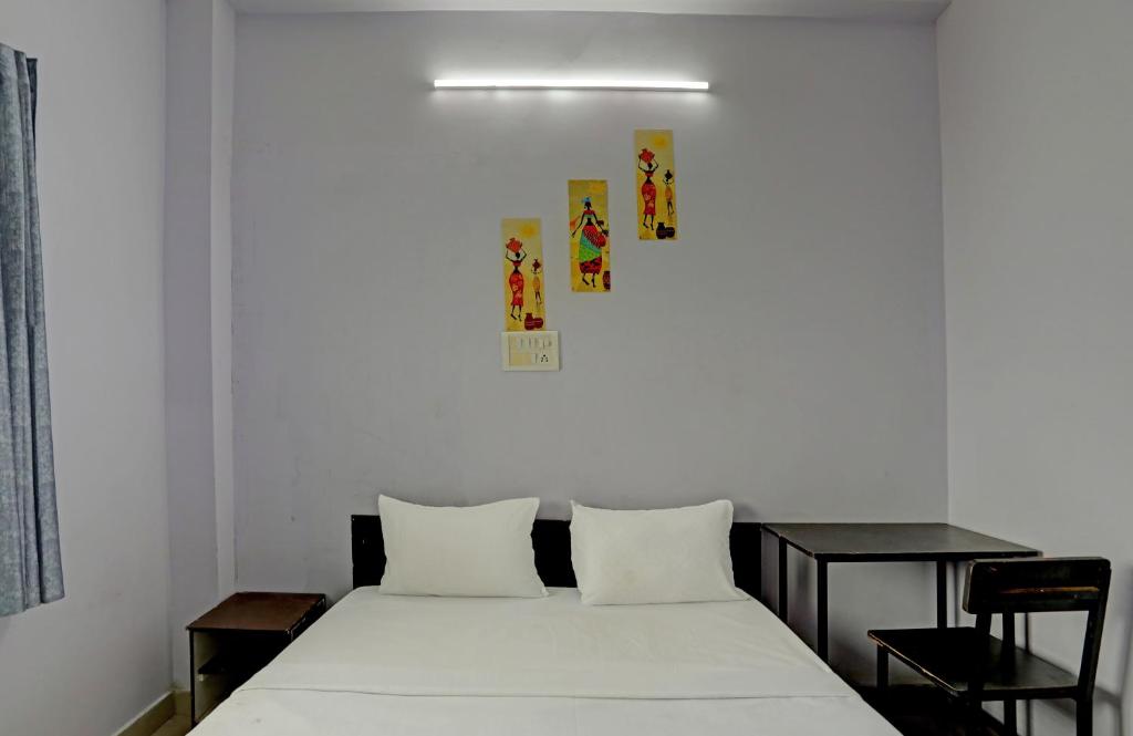 a bedroom with a white bed with two pillows at Hotel Sambodhi Palace in Bhopal