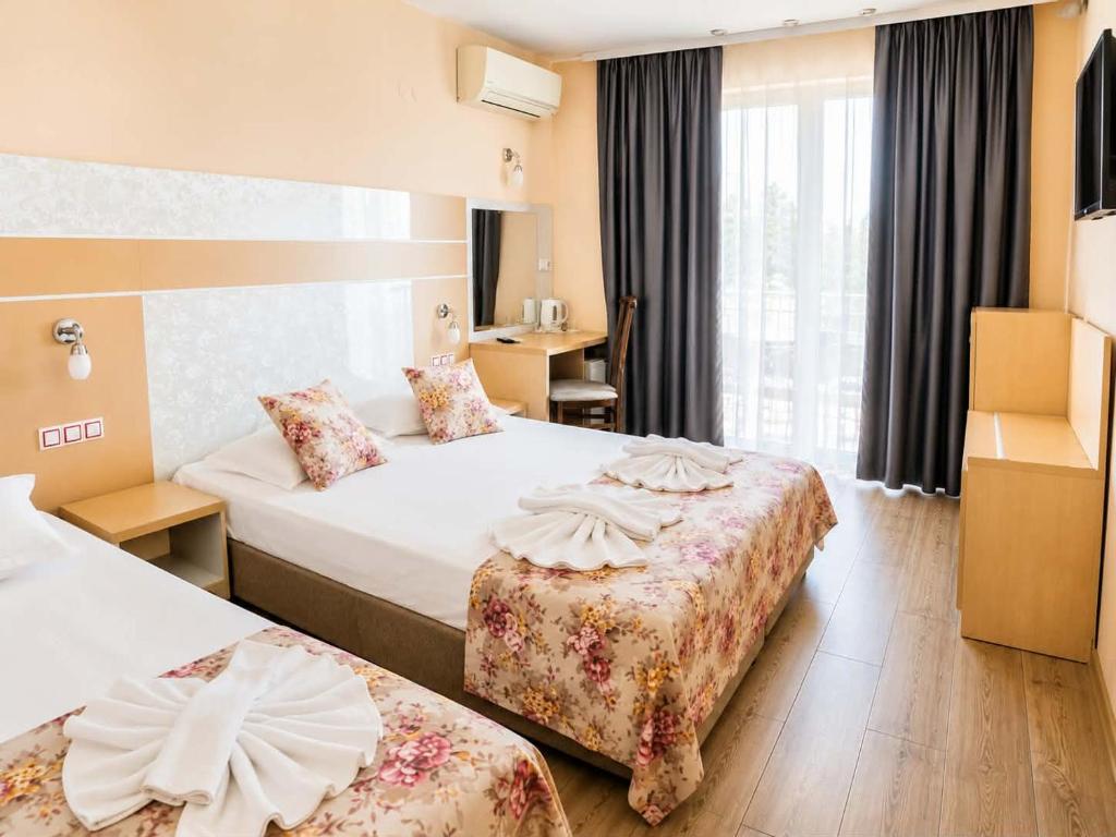 a hotel room with two beds and a desk at Palma in Burgas