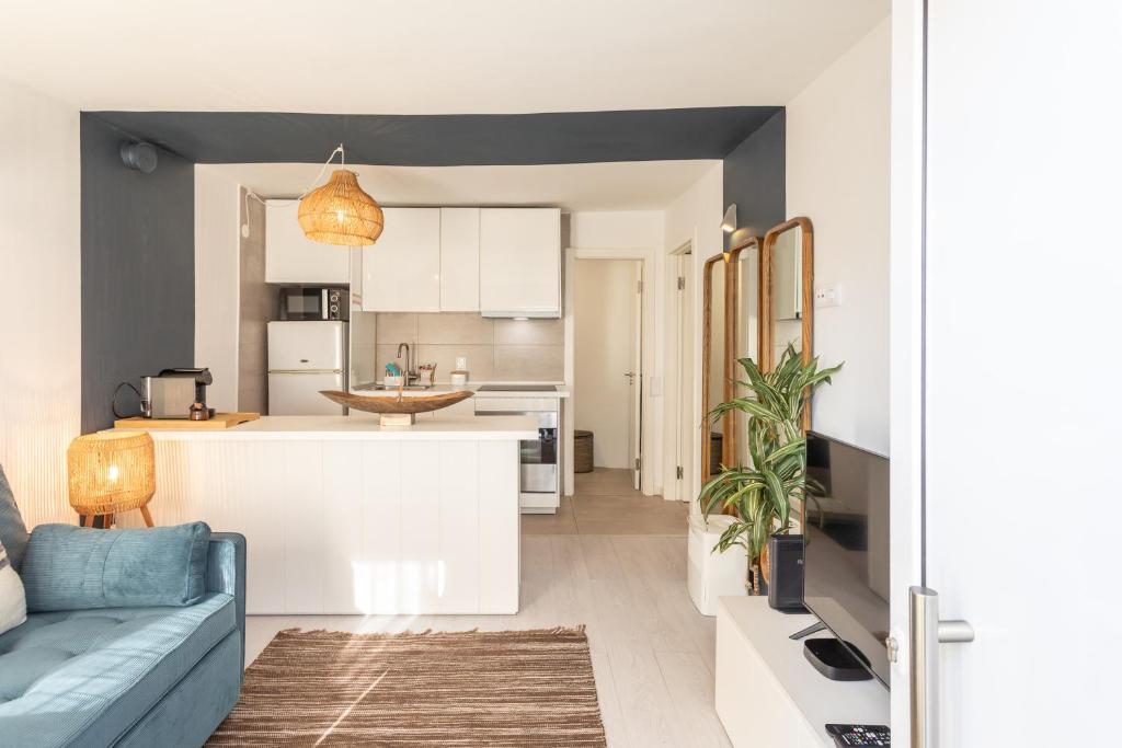 eine Küche und ein Wohnzimmer mit einer blauen Couch in einem Zimmer in der Unterkunft BeGuest Tiny Azure Apartament in Parede