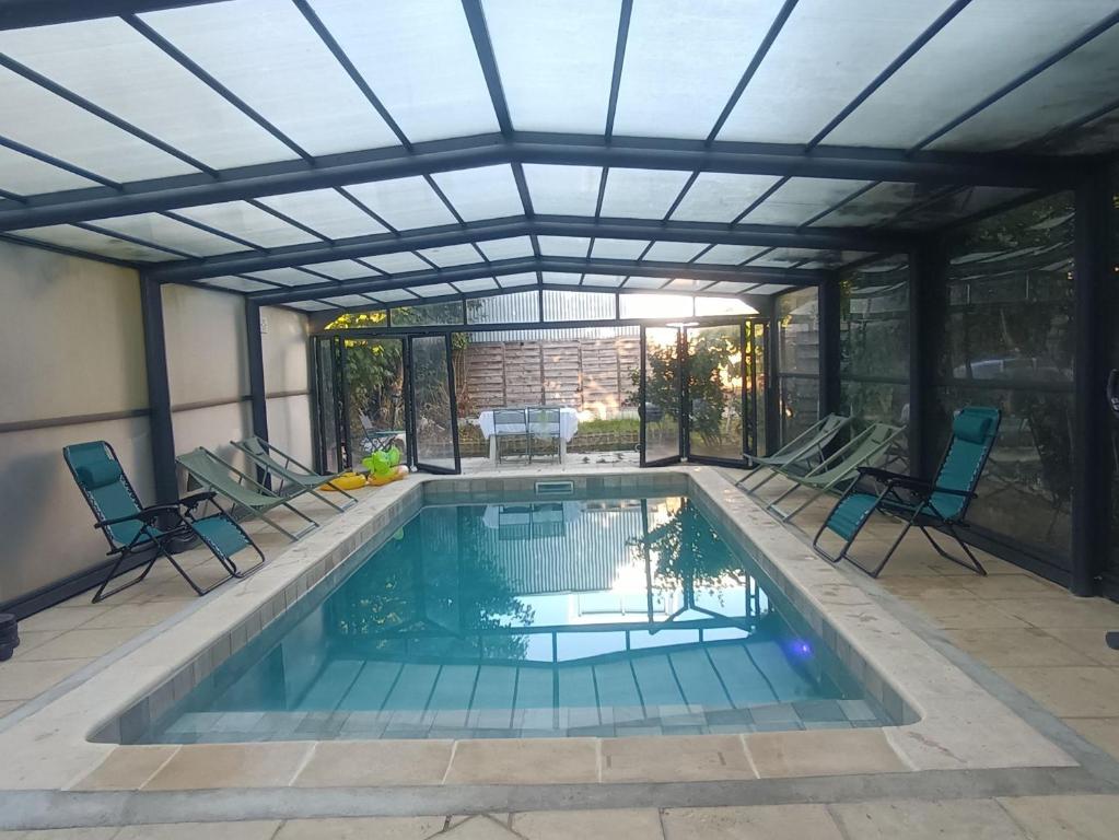 a swimming pool with a pergola and chairs around it at Charming House with Private Pool Near Paris - Maison du Bonheur in Gournay-sur-Marne