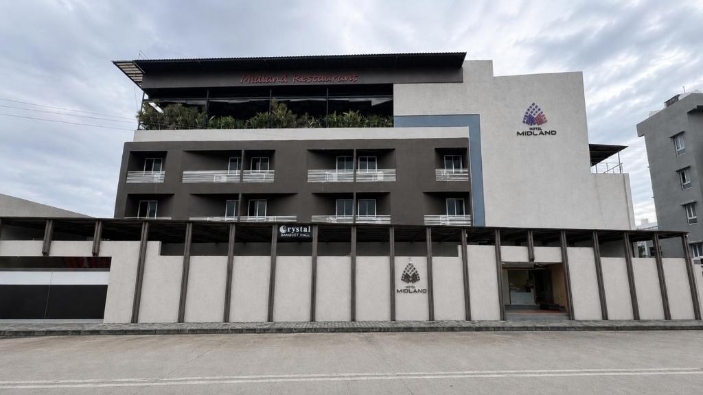 a building with a fence in front of it at Hotel Midland, Nanded in Nānded