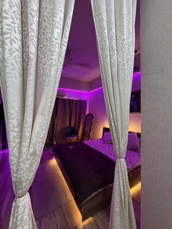 a bedroom with a bed with a curtain at Novastay in Greater Noida