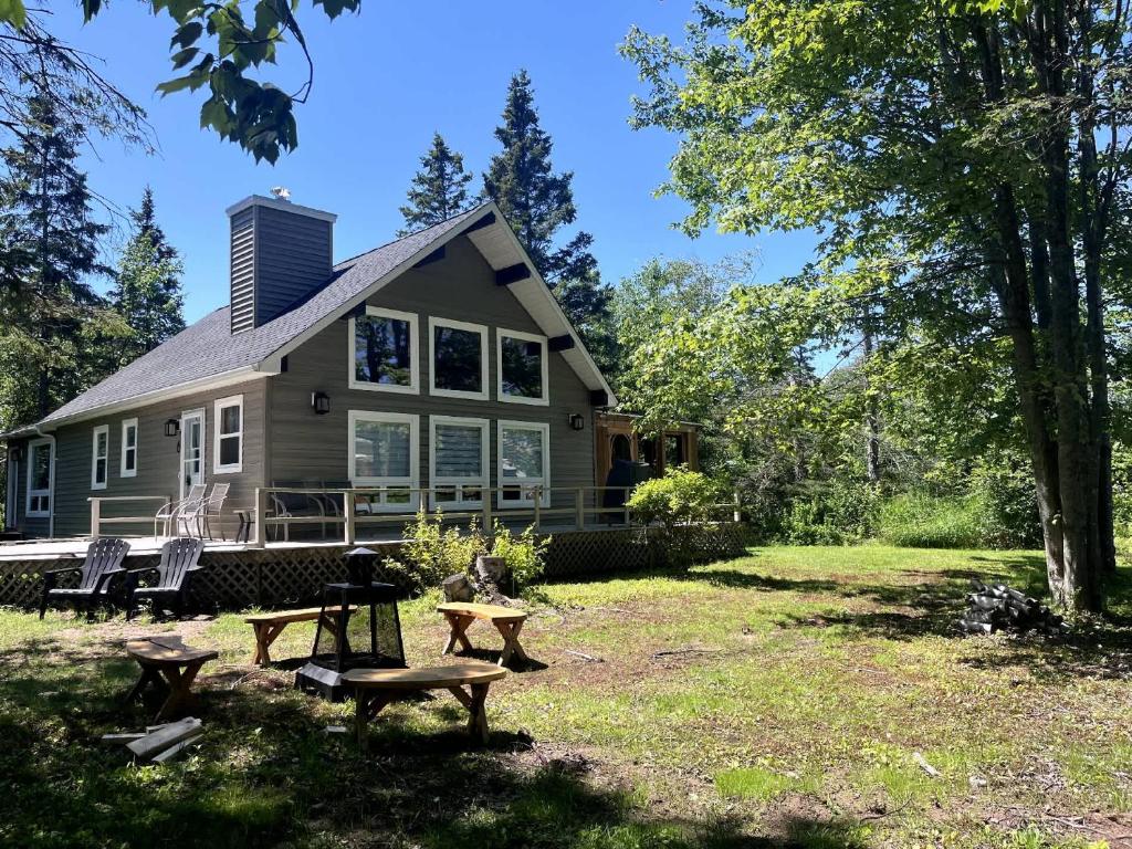 a house with picnic tables in front of it at Private Beach Escape - Chalet Ferdinand in Grand Barachois