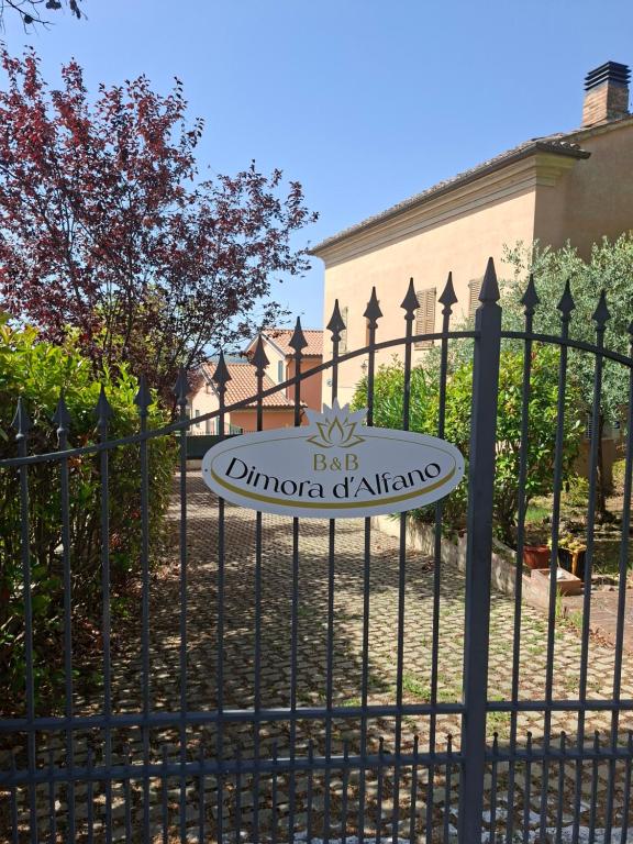 a sign on a fence in front of a building at B&B Dimora D'Alfano in SantʼAngelo in Pontano