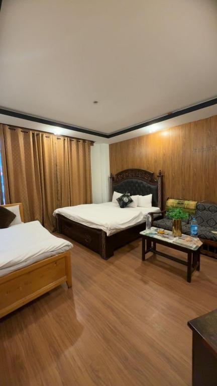 a hotel room with two beds and a table at Multiple Hotels in Malam Jabba Swat in Malam Jabba